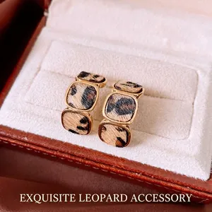 Vintage 18K gold-plated leopard print geometric hoop earrings on a leather box