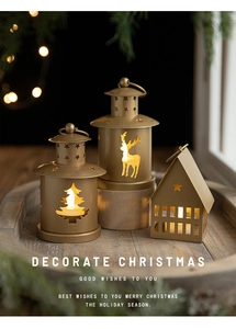 Three-piece gold metal Christmas lanterns with deer cutouts on a rustic wooden tray