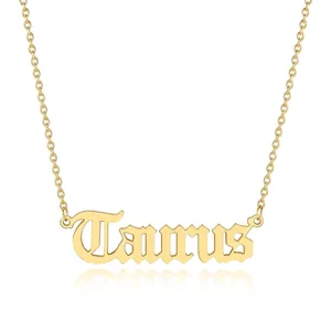 Detailed view of a gold Taurus zodiac pendant necklace with gothic lettering on a chain