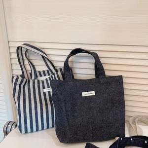 Close-up of blue striped and denim canvas tote bags with simple wish fabric label detail