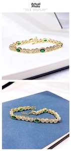 Close-up of gold-plated bracelet featuring green oval gemstones and sparkling cubic zirconia
