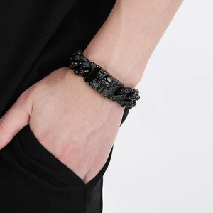 Close-up of black punk skull bracelet with cuban chain links worn on a male wrist