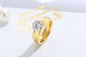 Macro detail of 6mm round zircon prong setting on polished gold plated titanium steel ring