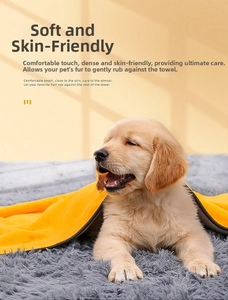 Close-up of soft yellow coral fleece pet towel with gray hem on a golden retriever puppy