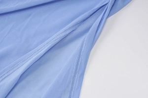 Detailed close-up of light blue mesh fabric texture and stitching of the dress