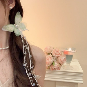 Detail of light green butterfly hair clip with long pearl tassels and mesh wings