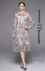 Detalle de vestido largo de gasa floral con volantes escalonados y cuello alto elegante