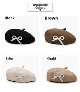 Detail view of knitted beret hats with white bows in black, brown, beige, and khaki