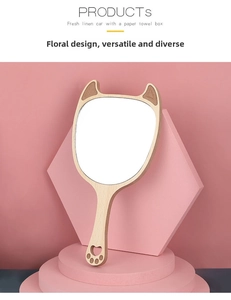 Detail view of the wooden hand mirror featuring cat ears and a hollow paw-shaped handle