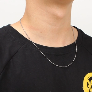 Silver stainless steel bead chain necklace worn by a model on a black t-shirt