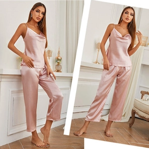 Detail of pink satin camisole top and matching trousers set with silky texture