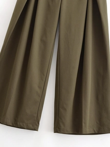 Detail of high waisted olive green wide leg pants with pleated fabric texture
