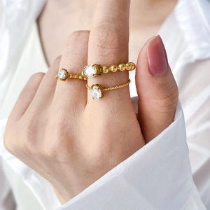 Close-up of three 18K gold plated stackable rings with oval and round cubic zirconia