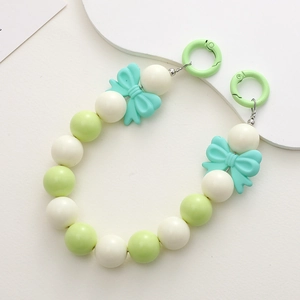 Detail of 16mm candy-colored acrylic beads and blue bow pendants for DIY phone charms