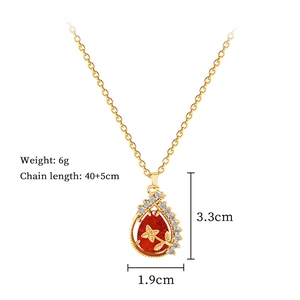 Detailed view of water drop pendant with red gemstone and gold flower motif on 40cm chain
