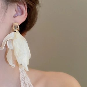 Detail shot of elegant floral fabric drop earrings with a sparkling champagne crystal