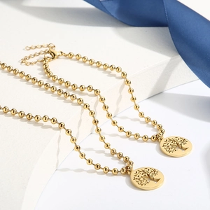 Dettaglio della collana a sfere dorate con ciondoli circolari traforati Albero della Vita