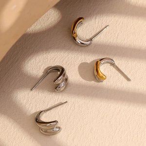 Detailed view of two-tone double-layered minimalist geometric drop earrings in gold and silver