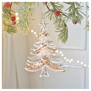 Clear acrylic snowflake christmas tree ornament with gold sequins on festive pine branch
