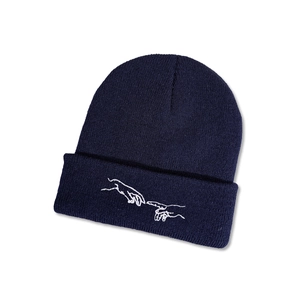 Gros plan détaillé du bonnet en maille bleu foncé avec broderie artistique blanche