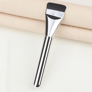 Macro detail of slim flat foundation brush with dense bristles and silver metal handle