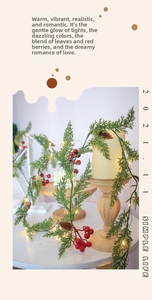 Close-up of Christmas pine garland with red berries, pinecones and warm LED lights