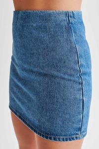 Détail rapproché d'une jupe en jean bleu montrant le tissu sergé et la coupe ajustée