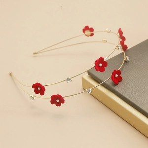 Close-up of dual-layer golden headband featuring red velvet flowers and white pearls
