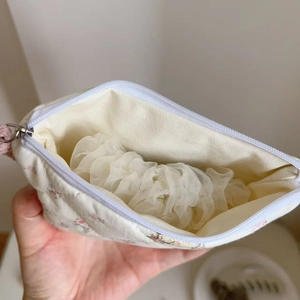 Detailed view of floral quilted pouch interior showing lining and storage capacity