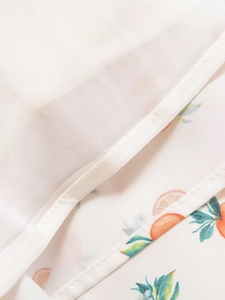 Gros plan sur tissu blanc avec motif orange et détails de couture de haute qualité