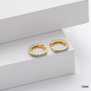 Detailed view of 7mm gold huggie earrings with turquoise gemstone inlay detail