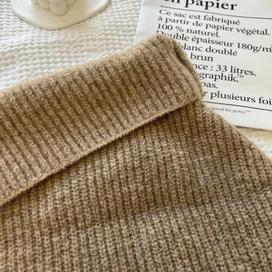Close-up of chunky ribbed knit brown winter shawl showing thick wool texture and detail