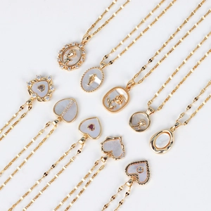Detailed view of assorted 18K gold plated necklaces featuring white shell pendants and stones