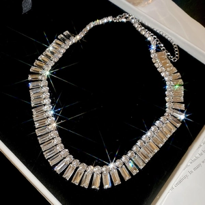Detailed close-up of a silver-toned luxury tassel necklace with sparkling rectangular crystals