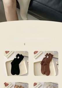 Close-up of ribbed cotton crew socks with minimalist white fabric labels in coffee and black