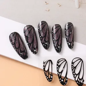 Detail of almond nails with black base and purple glitter butterfly wing patterns