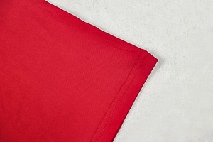 Close-up of red knit dress sleeve showing high-quality double-needle flat stitching detail