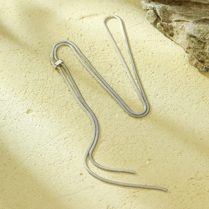 Detail of adjustable silver snake chain necklace with metallic sliding buckle on rock surface