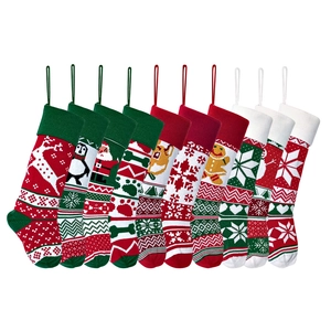 Nine assorted knit Christmas stockings with reindeer and snowflake patterns in red and green