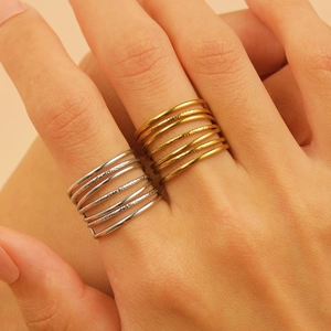 Detailed view of dual-tone 18K gold and silver stacked multi-layer textured ring set