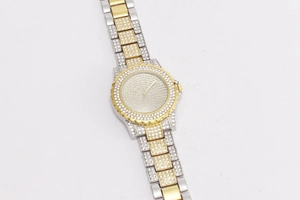 Detail of luxury iced-out silver and gold tone quartz watch with crystal inlay