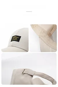 Close-up of beige baseball cap featuring embroidered label and adjustable metal buckle