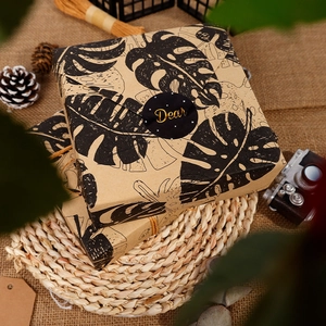 Retro kraft gift wrapping paper with black tropical leaf patterns in a vintage setting
