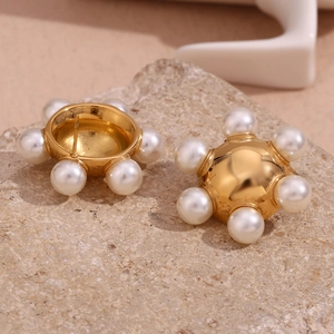 Detail of 18K gold-plated stainless steel wheel earrings with pearl center on stone