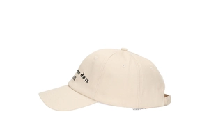 Detail of beige cotton baseball cap with black letter embroidery and adjustable strap