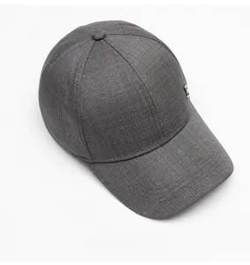 Detailed texture of a dark grey autumn baseball cap with a stylish silver metal logo