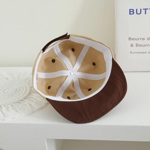 Detail view of cotton baby baseball cap showing inner stitching and contrast color brim