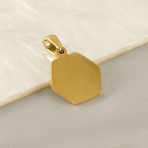 Close-up of a polished golden hexagonal stainless steel pendant with a simple ring bail