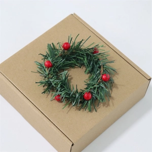 Christmas candle ring with red berries and pine needles on a kraft paper gift box