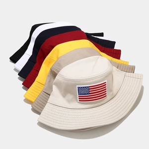 Multiple colors of cotton bucket hats with American flag embroidery shown in a stack